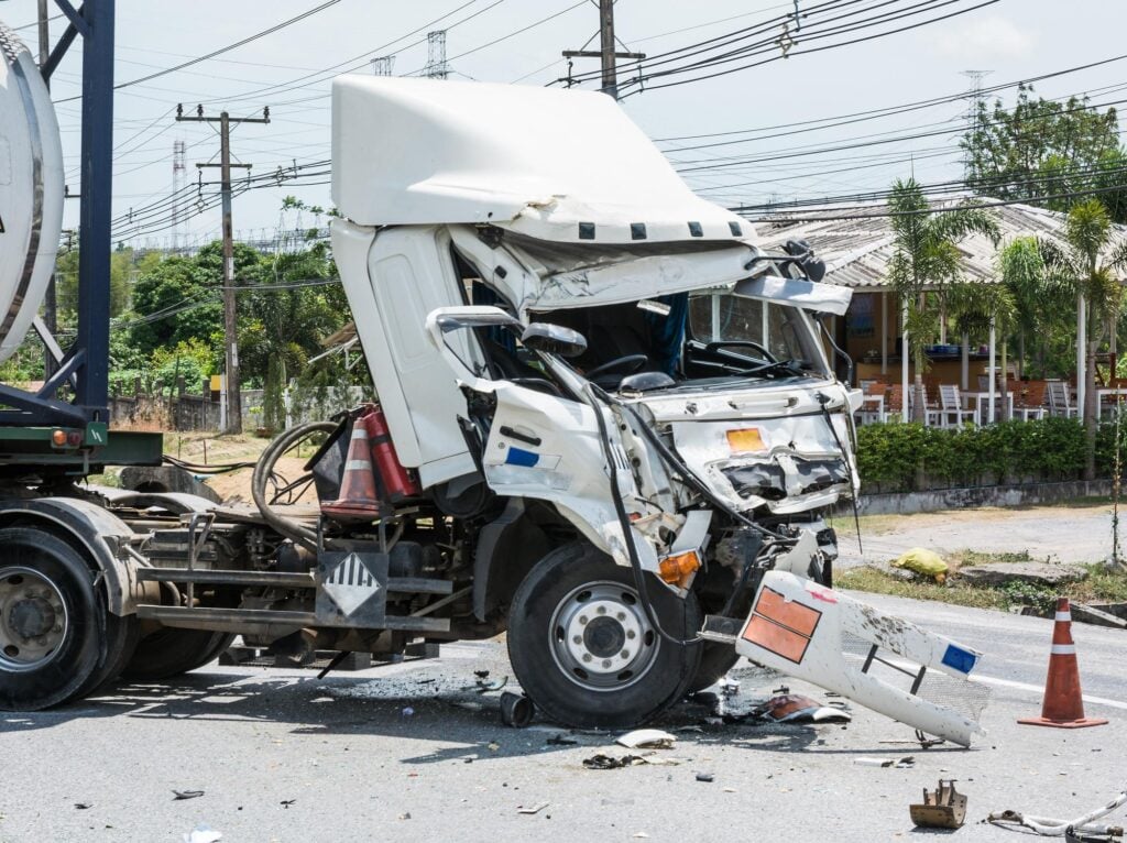 Smashed semi cab after an accident showing metal scraps scattered in road