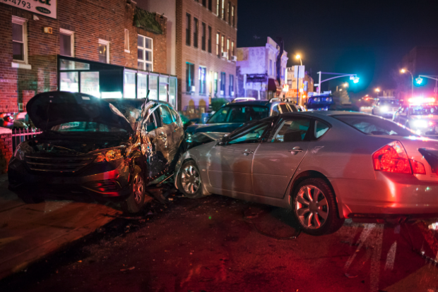 Multiple cars involved in an accident in the city at night.